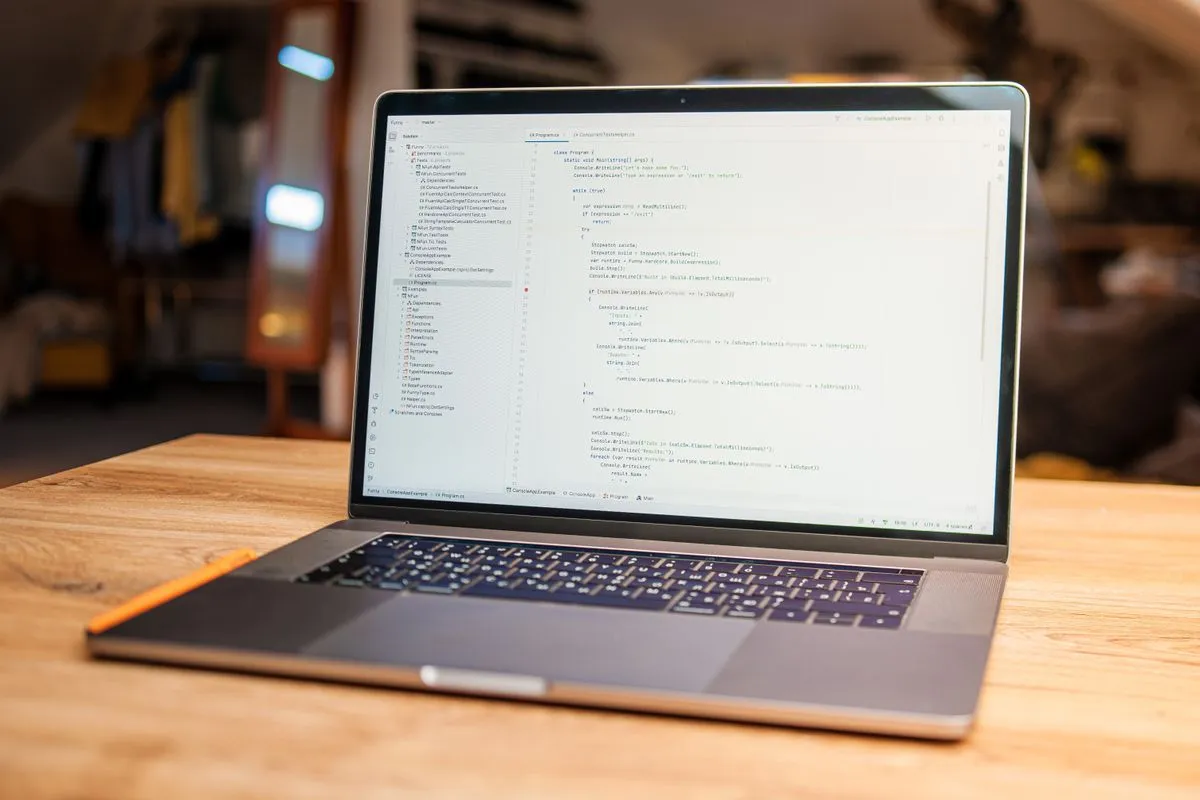 Open laptop on a wooden table showing a code editor and file tree