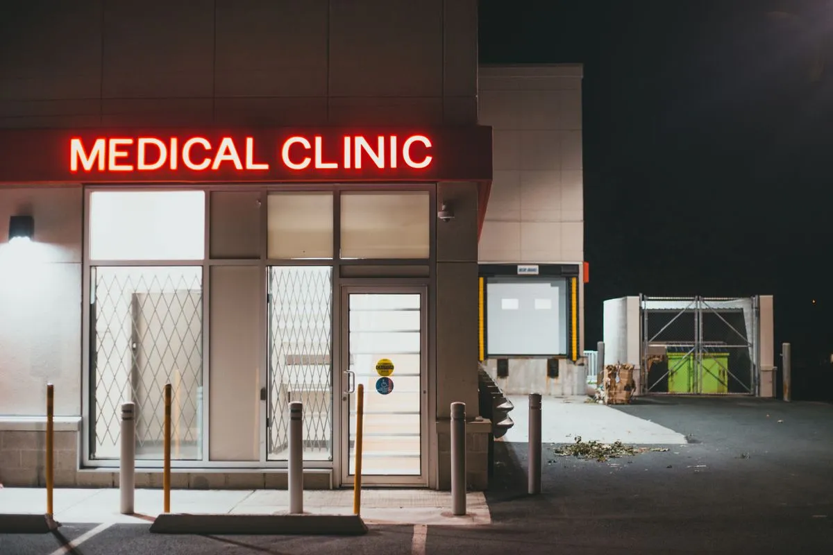 Small storefront medical clinic at night under a red neon sign